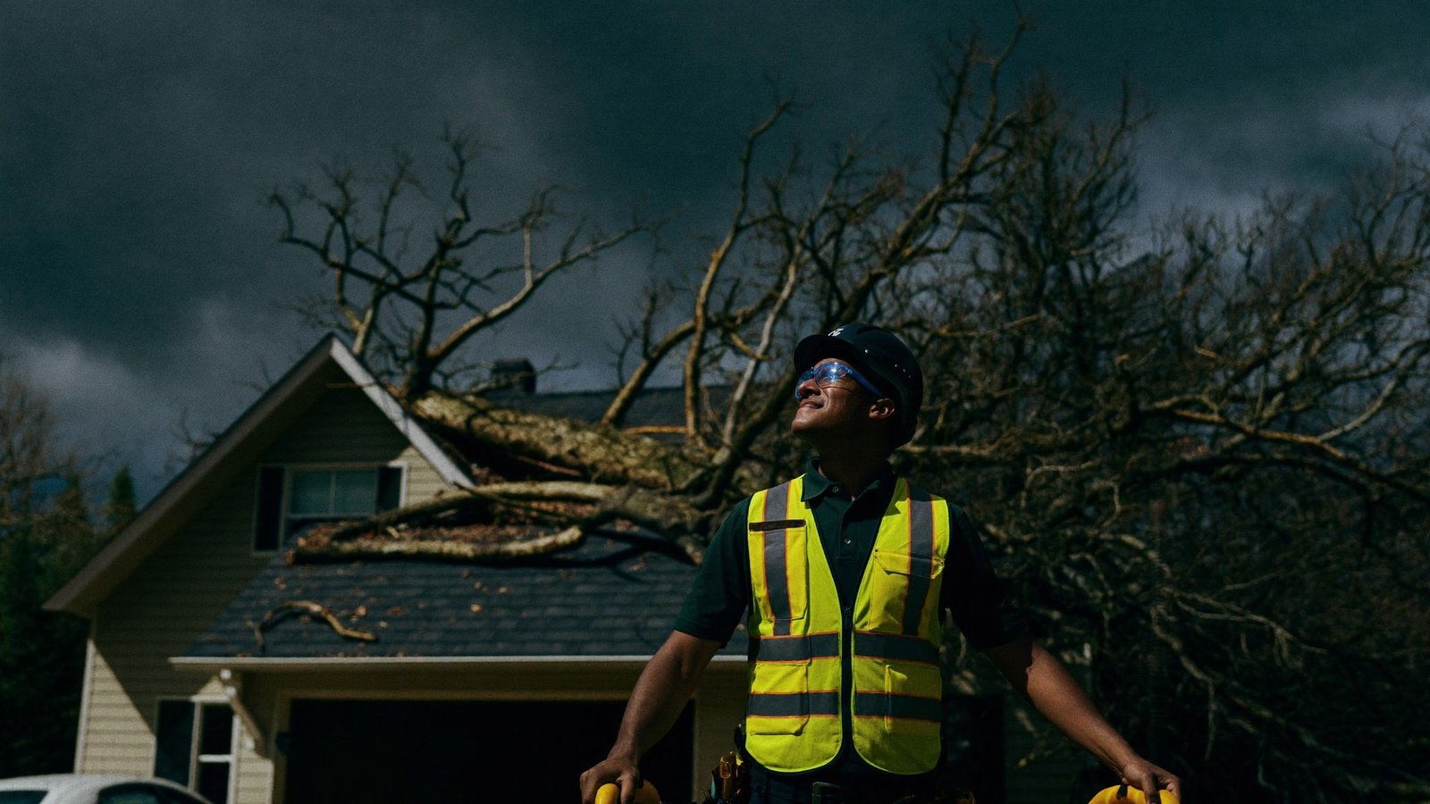 Tree crew responding to storm damage on a home at dusk